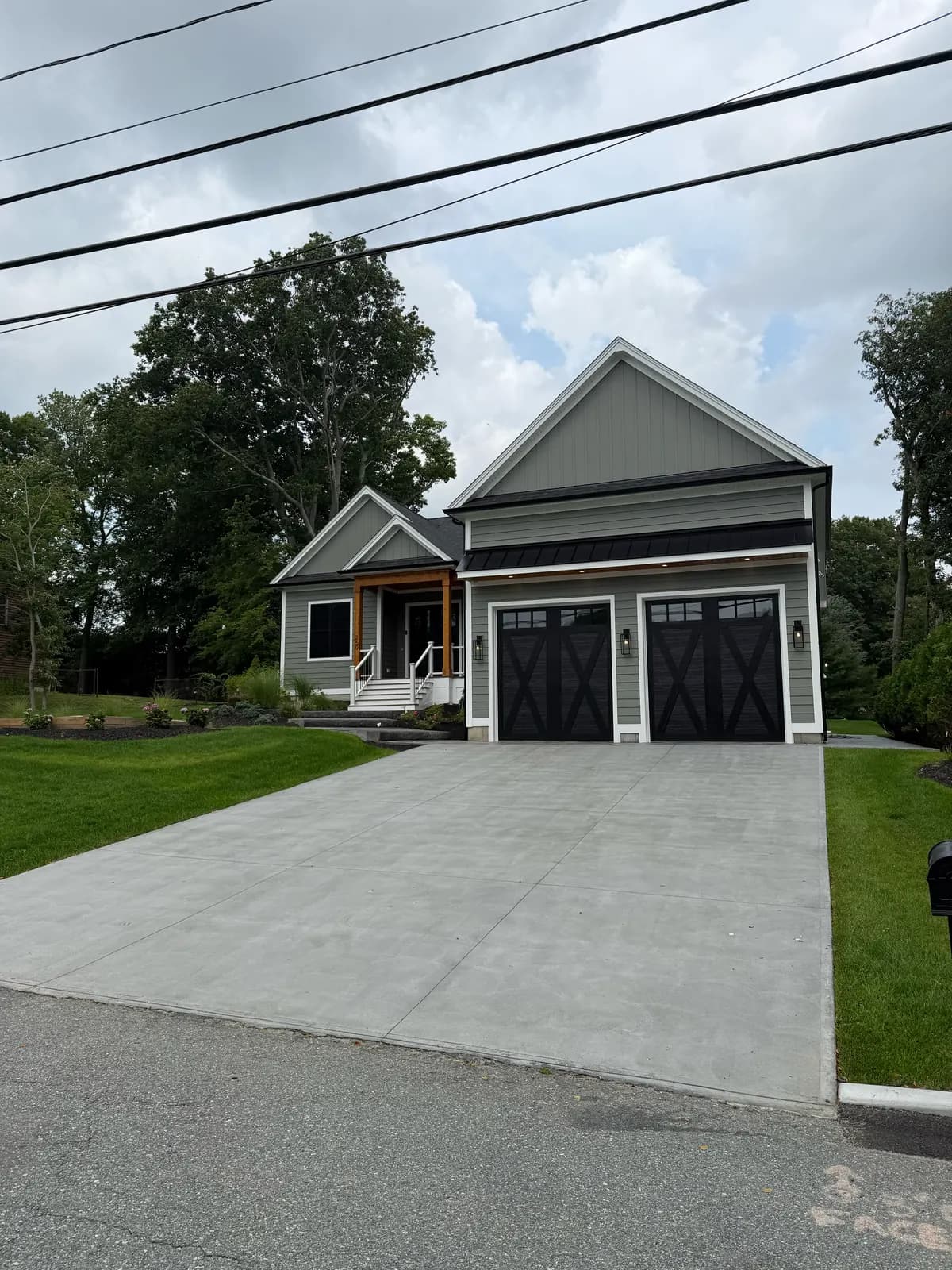 New construction home with a finished poured-concrete driveway running to a two-car garage.