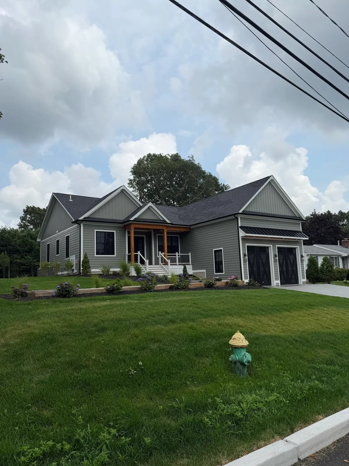 Completed residential build seen from the street with finished grading and established front lawn.